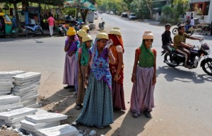 Sarta Kalara (C), a construction worker, stands among other female workers in Ahmedabad, India, April 20, 2016. Kalara says she has no option but to tether her daughter Shivani to a stone despite her crying, while she and her husband work for 250 rupees ($3.8) each a shift digging holes for electricity cables in the city of Ahmedabad. There are about 40 million construction workers in India, at least one in five of them women, and the majority poor migrants who shift from site to site, building infrastructure for India's booming cities. Across the country it is not uncommon to see young children rolling in the sand and mud as their parents carry bricks or dig for new roads or luxury houses. REUTERS/Amit Dave SEARCH "TIED TODDLER" FOR THIS STORY. SEARCH "THE WIDER IMAGE" FOR ALL STORIES TPX IMAGES OF THE DAY