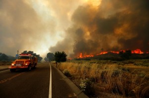 Firefighters move to try and head off a fast moving wildfire as it burns near Potrero, California