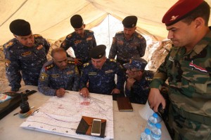 Iraqi security officers inspect a map near Falluja