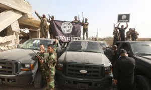 Shi'ite fighters hold an Islamic State flag, which they pulled down after clashes with IS militants, in Saqlawiya