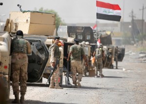 Iraqi army soldiers carry their weapons as they gather in the center of Falluja