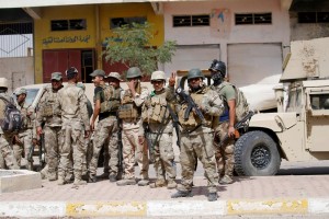 Iraqi army soldiers carry their weapons as they gather in the center of Falluja