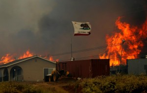 Flames come close to a home as firefighters battle a wildfire as it burns near Potrero, California,