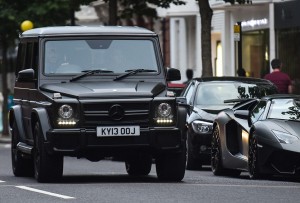 A Mercedes-Benz G63 drives past a Lamborghini Aventador on Sloane Street in London, England on August 09 2016.