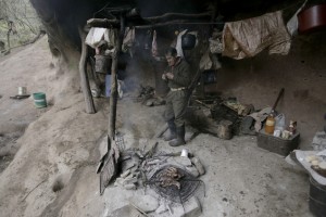 In this July 28, 2016, Pedro Luca cooks meat fillets and sausage inside a mountain cavern near San Pedro de Colalao, Argentina's northern province of Tucuman. Luca has lived in the cave in northern Argentina for 40 years. The 79-year-old survives without running water or electricity in his cavern high in a mountain in northern Tucuman province. Luca has become a legend in San Pedro de Colalao, and town dwellers often give him food and supplies. (AP Photo/Alvaro Medina)