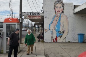 Pedestrians walk past a mural of Democrat US presidential nominee Hillary Clinton clad in a swimsuit, created by street artist Lushsux, in West Footscray in Melbourne on July 30, 2016. An Australian mural of US presidential nominee Hillary Clinton in a revealing, stars and stripes swimsuit may be taken down, after it has reportedly been deemed offensive. / AFP / Paul Crock / RESTRICTED TO EDITORIAL USE - MANDATORY MENTION OF THE ARTIST UPON PUBLICATION - TO ILLUSTRATE THE EVENT AS SPECIFIED IN THE CAPTION (Photo credit should read PAUL CROCK/AFP/Getty Images)