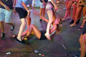 A girl laughs as she sits on the pavement in Punta Ballena street in Magaluf holiday resort in Calvia on the Spanish Mallorca Island on July 19, 2014. Known among some tourists as Shagaluf, the resort has suffered particularly bad press over the past 12 months after a video showing a Northern Irish teenage girl performing sex acts on a group of men during a bar crawl went viral last summer. It is estimated 1 million Britons visit the region each year, bringing 800 million euros (866 million dollars) to the local economy, but the council is desperate to improve the reputation of destination, reported British journal The Guardian. AFP PHOTO / JAIME REINA (Photo credit should read JAIME REINA/AFP/Getty Images)