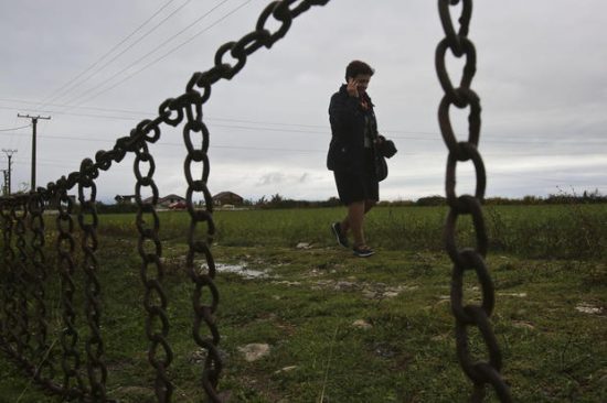 In this Friday, Oct. 7, 2016 photo, Albanian teacher Liljana Luani walks towards a family house, in northern Albania. Where most people and even police fear to set foot, Liljana Luani takes books, household supplies, and a lifetime of experience on how to help families marked for murder. The 56-year-old school teacher from Shkodra in northern Albania uses her spare time to travel to remote hillside villages where children are trapped in a centuries-old tradition of blood feuds and hidden by their families. (AP Photo/Visar Kryeziu)