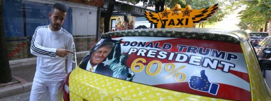 Uljan Kolgjegja, 37, an Albanian taxi driver, points to a picture of U.S. Republican candidate Donald Trump in his car in the Albanian capital, Tirana, Monday, Sept. 26, 2016. Kolgjegja said Monday he was prompted to decorate his taxi with pictures of the Republican candidate after Albania’s Prime Minister Edi Rama said Trump could be "a real threat to Albanian-American ties." The move has attracted attention in the capital Tirana and Kolgjegja says he is earning more money than ever before in his 13 years as a taxi driver. (AP Photo/Hektor Pustina)