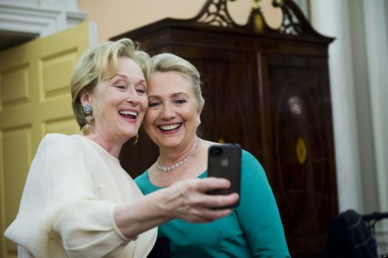 Actress Meryl Streep uses her iPhone to get a photo of her and Secretary of State Hillary Rodham Clinton following the State Department Dinner for the Kennedy Center Honors gala Saturday, Dec. 1, 2012 at the State Department in Washington. (AP Photo/Kevin Wolf)