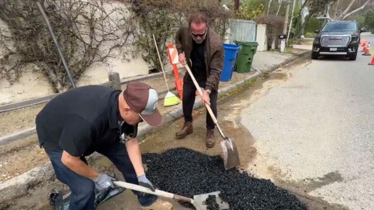 Arnold Schwarzenegger filmohet duke mbushur gropat e rrugës të lagjes së tij