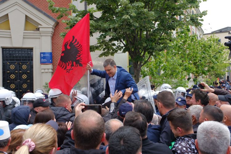 Me flamur në dorë, Tedi Blushi tenton të kalojë mbi kordonin e policisë