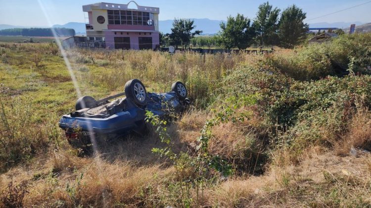 Makina del nga rruga në Maliq dhe përmbyset, dy të plagosur